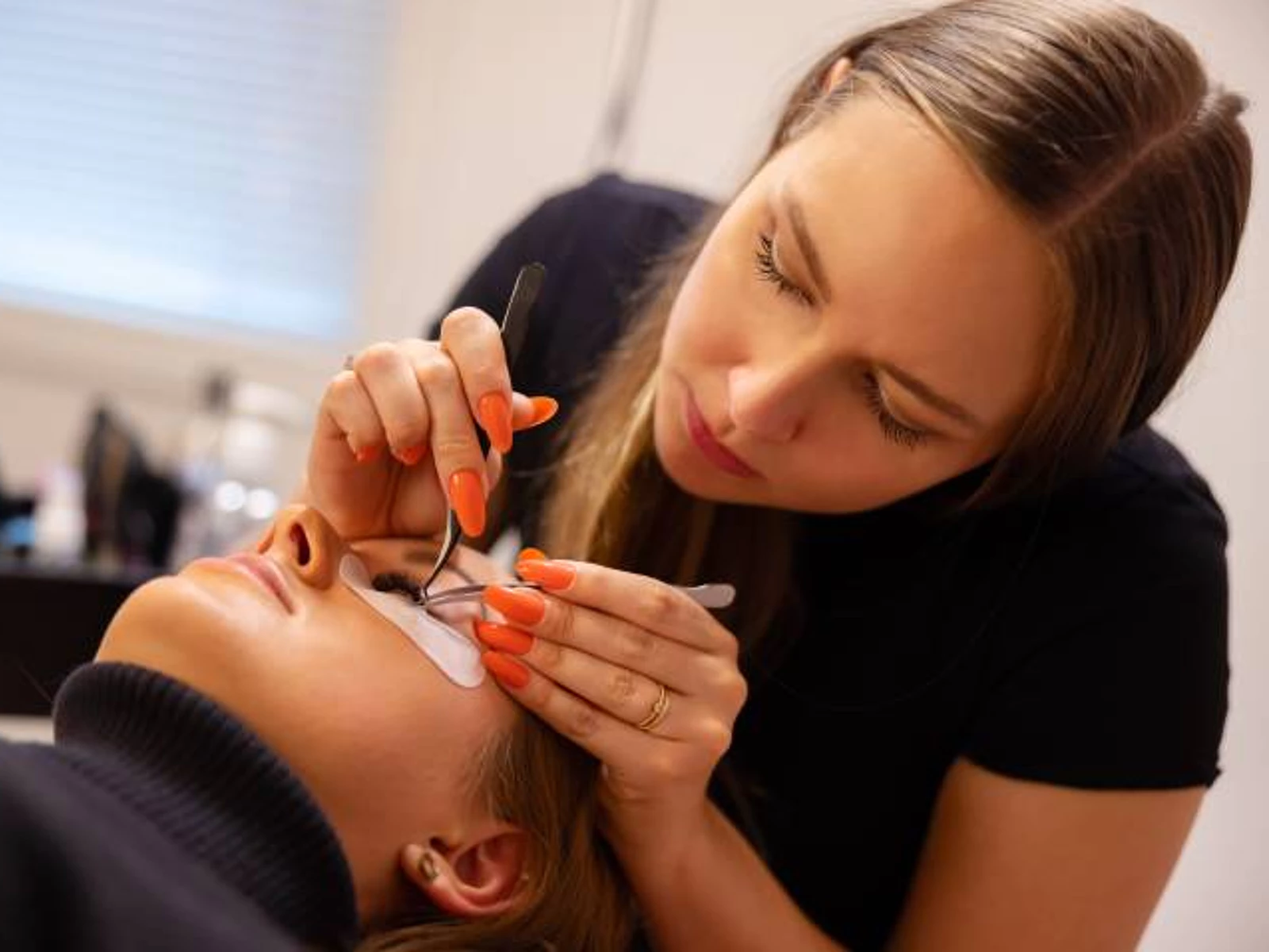 1666662433189_technician using tweezers for eyelash extension procedure
